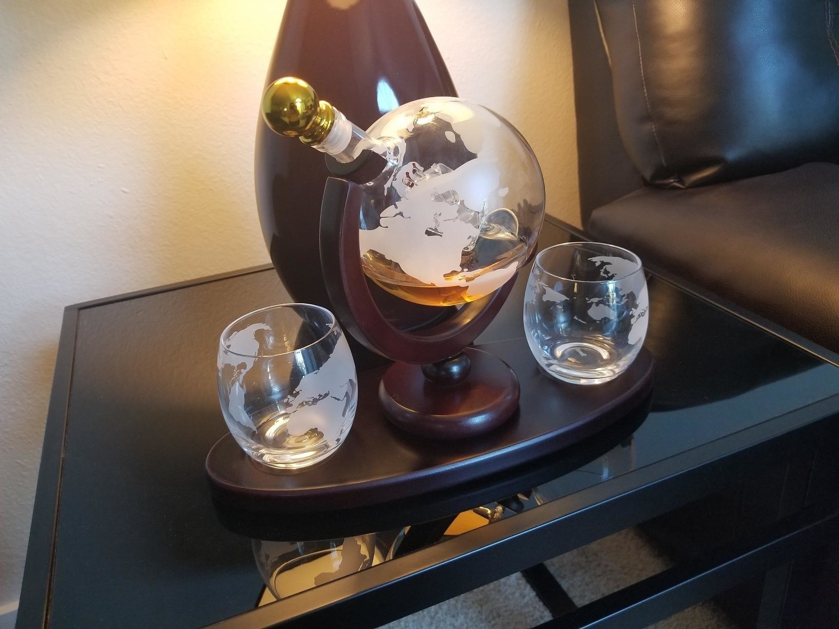 the decanter with whiskey in it and two engraved glasses next to it