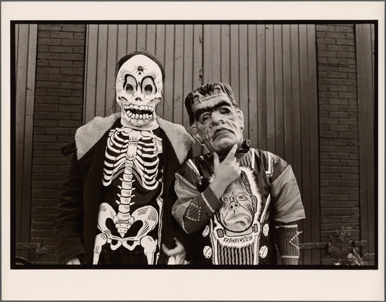 A young kid dressed as a skeleton stands beside a child dressed as Frankenstein&#x27;s monster