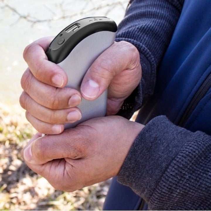 a model cupping their hands around the hand warmer