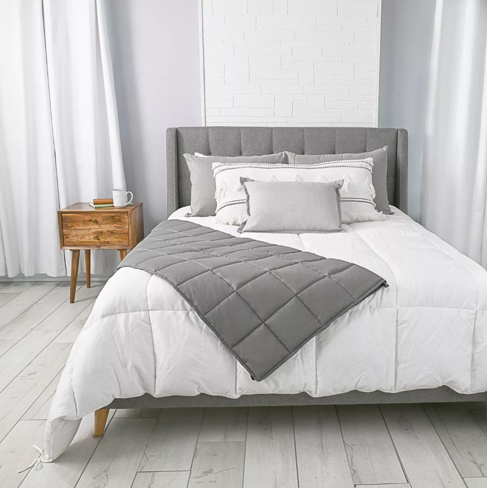 Gray weighted blanket on white bed