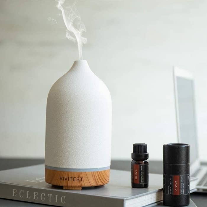 diffuser placed on top of book next to essential oils