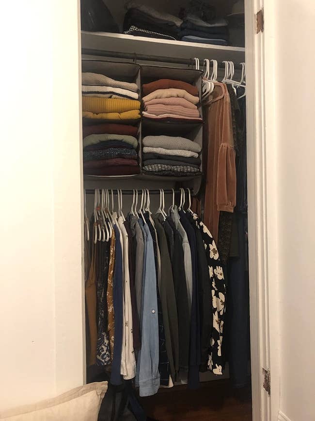 reviewer's closet with four-cube organizer filled with sweaters hung on rod; rod at bottom of organizer holds tops