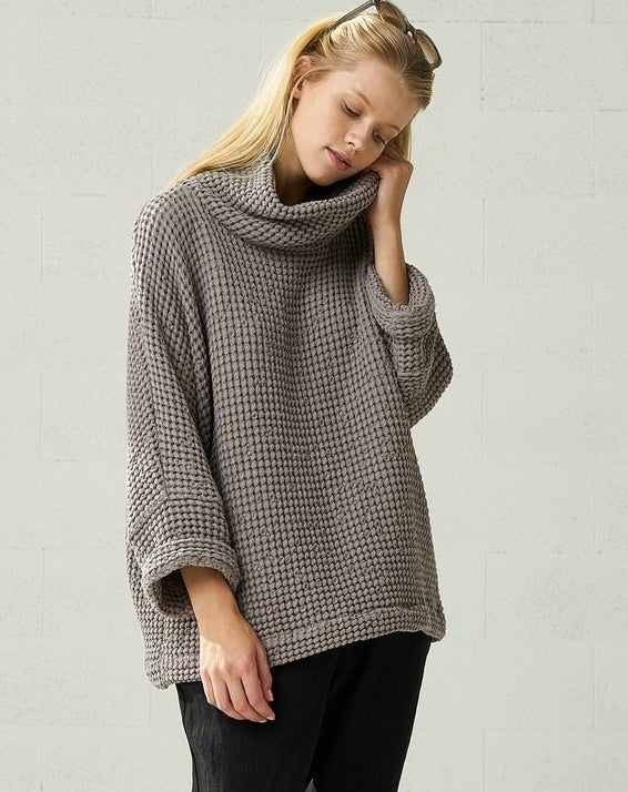 A model wearing the chunky linen sweater in gray, paired with loose black pants
