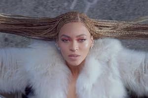 An overhead shot of Beyoncé as she hangs out the passenger side of a car
