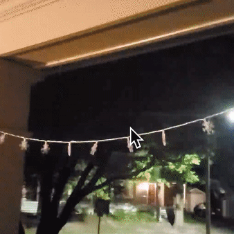 Reviewer GIF of the blinking snowflake string lights hung on a porch
