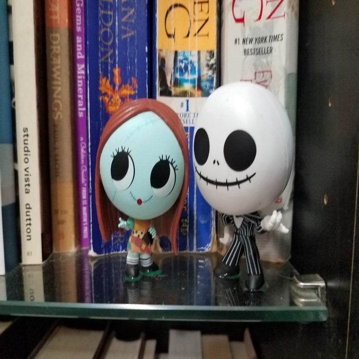 museum gel holding down "Nightmare Before Christmas" standing toys on shelf