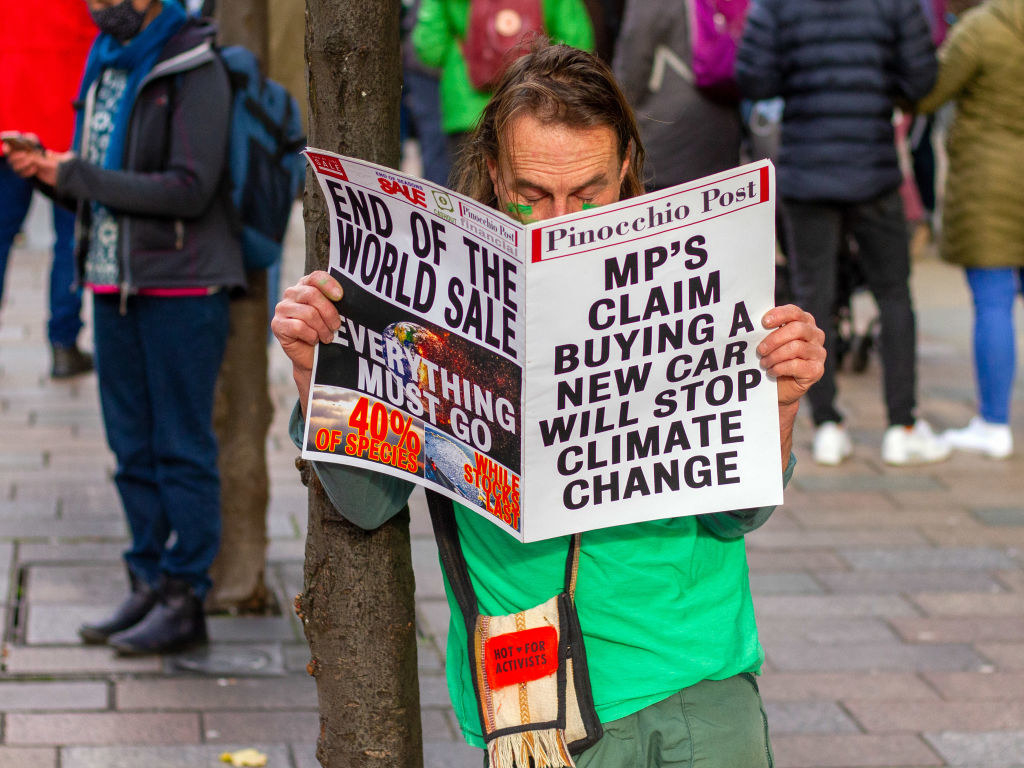 A protester holding a sign that looks like a newspaper