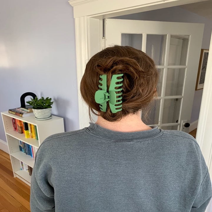 reviewer puts hair up with giant green claw clip