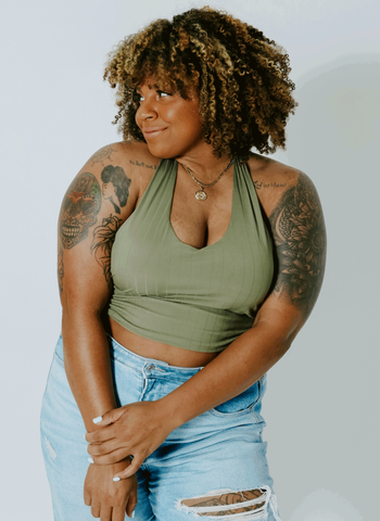 model in green halter bra top and distressed jeans