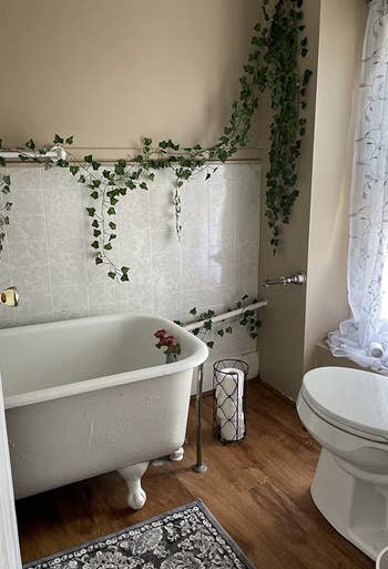 A reviewer showing the ivy garland hanging and draped along the walls in the bathroom