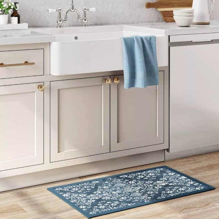Blue and white patterned comfort mat under kitchen sink