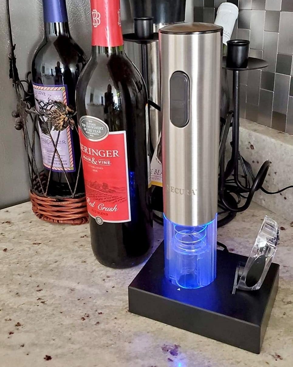 a reviewer photo of the electric wine opener on the illuminated charging dock