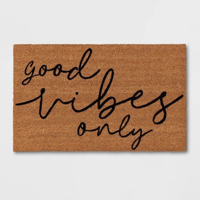 the mat laying flat and reads &quot;good vibes only&quot; in cursive
