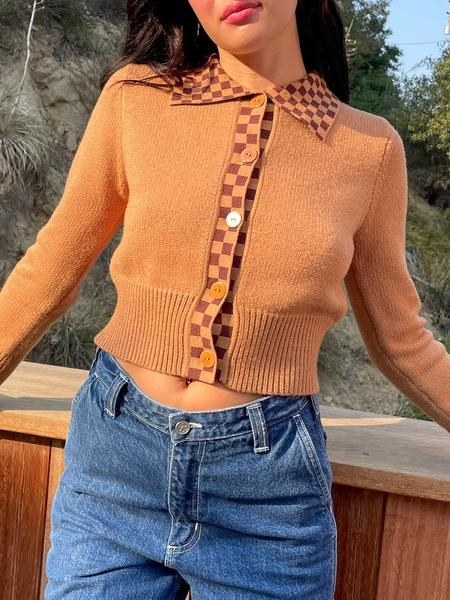 A model wearing the chestnut-colored cardigan with blue jeans