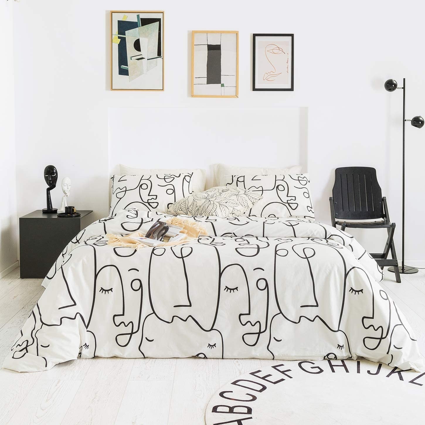 The duvet and pillow set with a white background and black one-line work of faces.