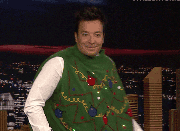 A gif of Jimmy Fallon awkwardly dancing in a Christmas tree sweater
