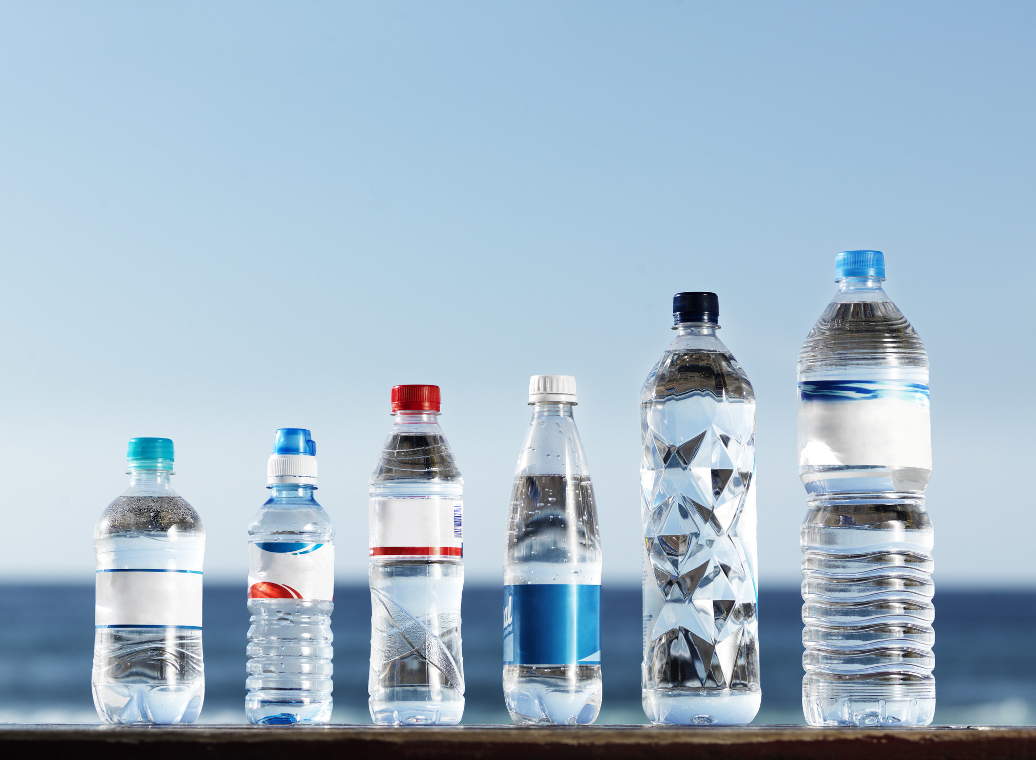 A row of plastic water bottles from different companies
