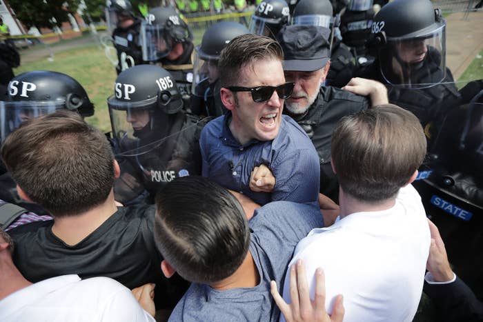 A screaming man is surrounded by police wearing riot gear