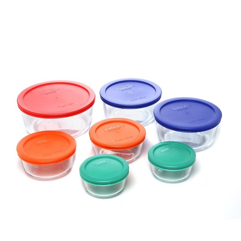 seven pyrex glass containers with different colored plastic lids