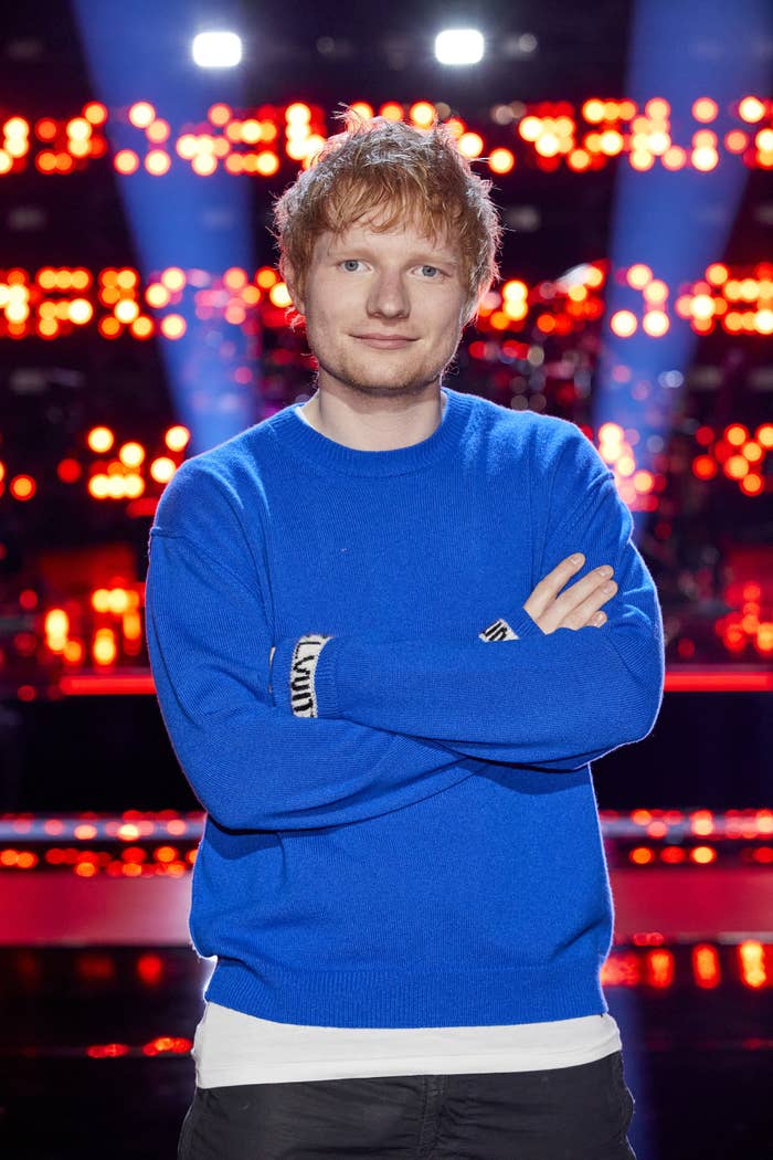Ed Sheeran stands with his arms crossed
