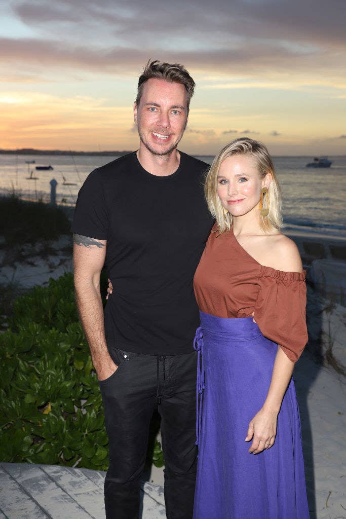 Dax Shepard (L) and Kristen Bell pose by the beach