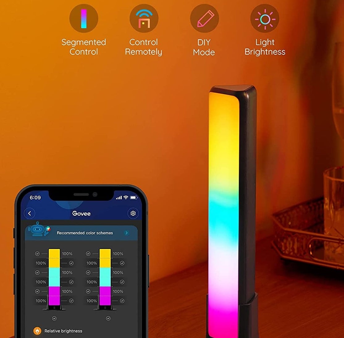 The smart light bar on a table and a phone with the controls on it