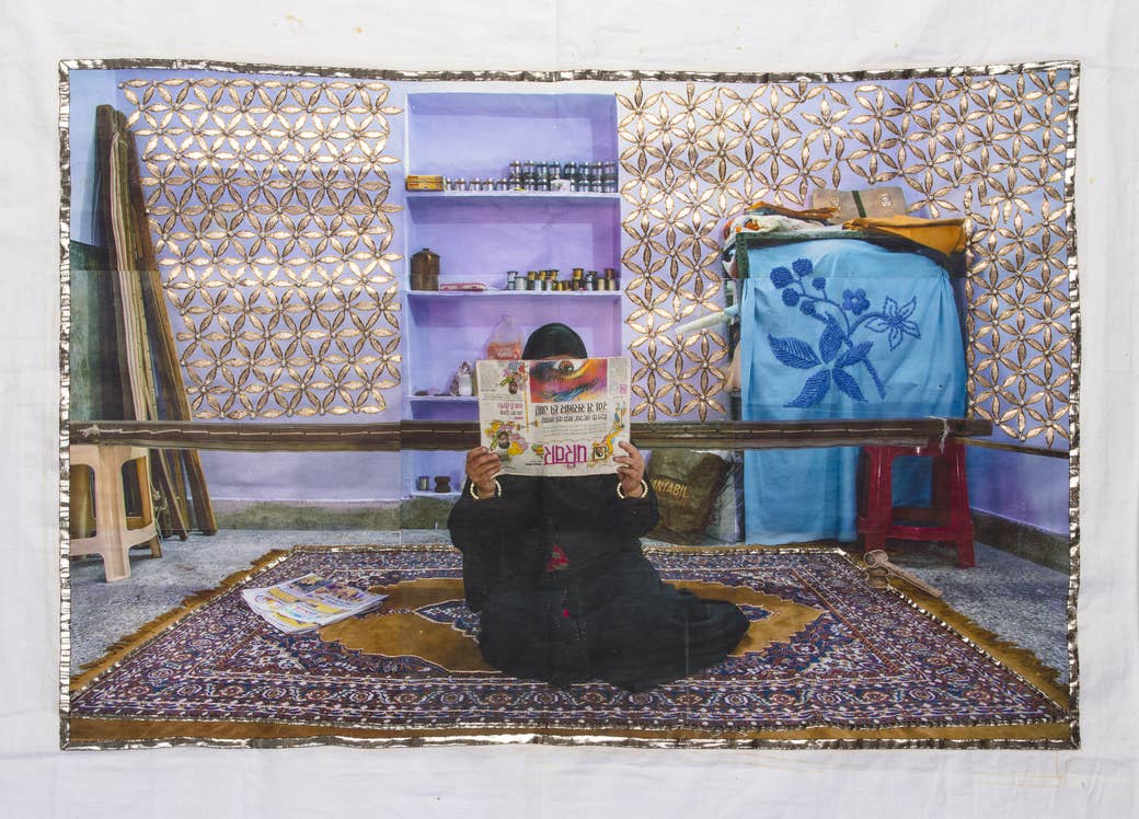 A woman holds a newspaper in front of her face in an embroidered photo