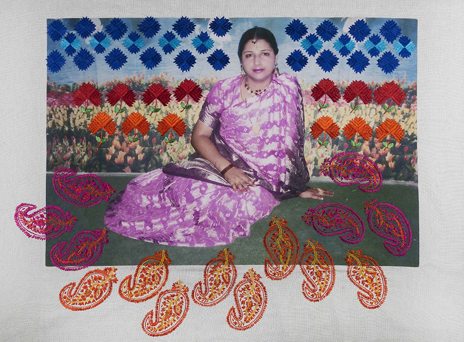 A woman in a sari sits on the ground in front of flowers, heavy details and embroidery are on top of her photo