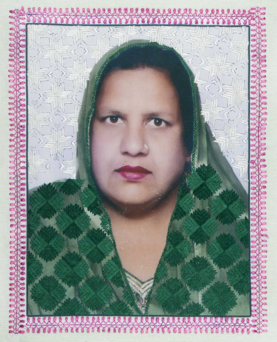 A woman looks directly into the camera, her head covering and the border of the photo are embroidered