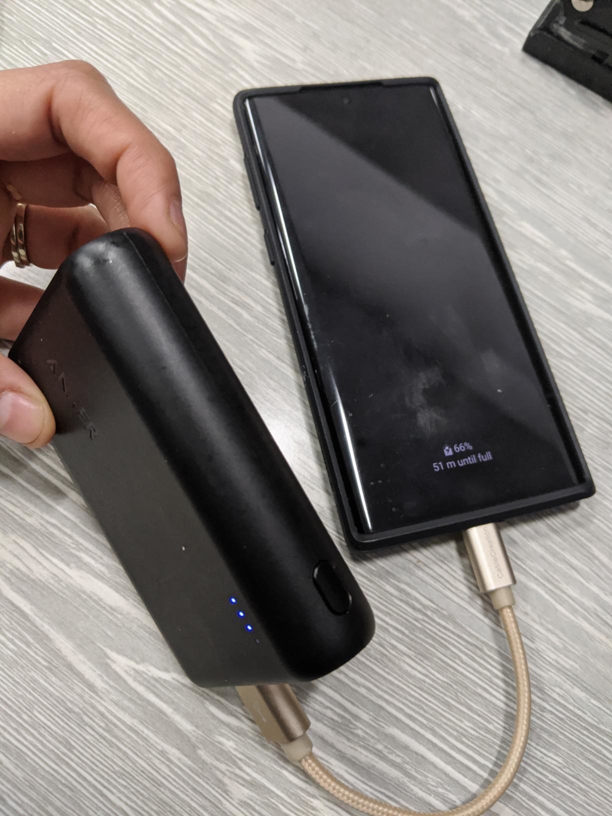 Reviewer photo of the external battery being used to charge a smartphone