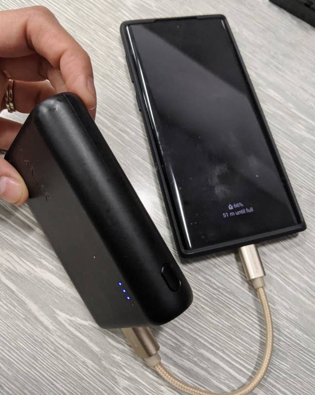 Reviewer photo of the external battery being used to charge a smartphone