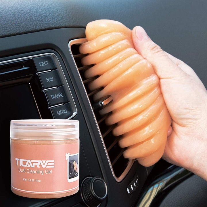 Person using orange putty on their car air vents
