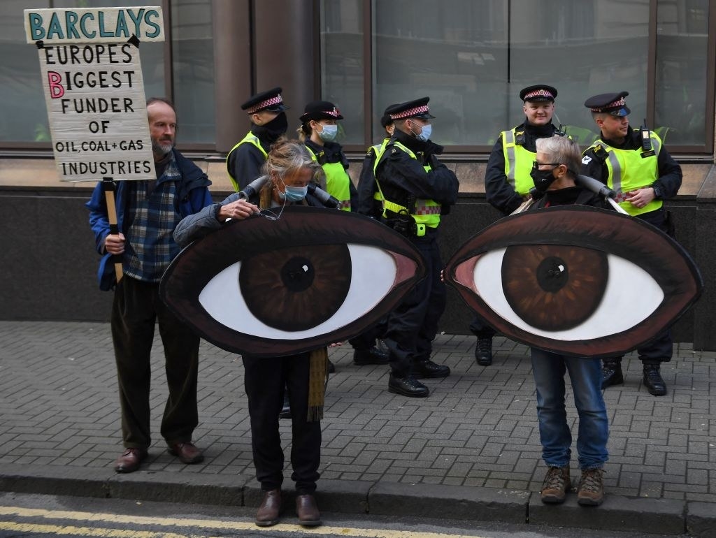 A protester holding a sign that looks like a giant pair of eyes