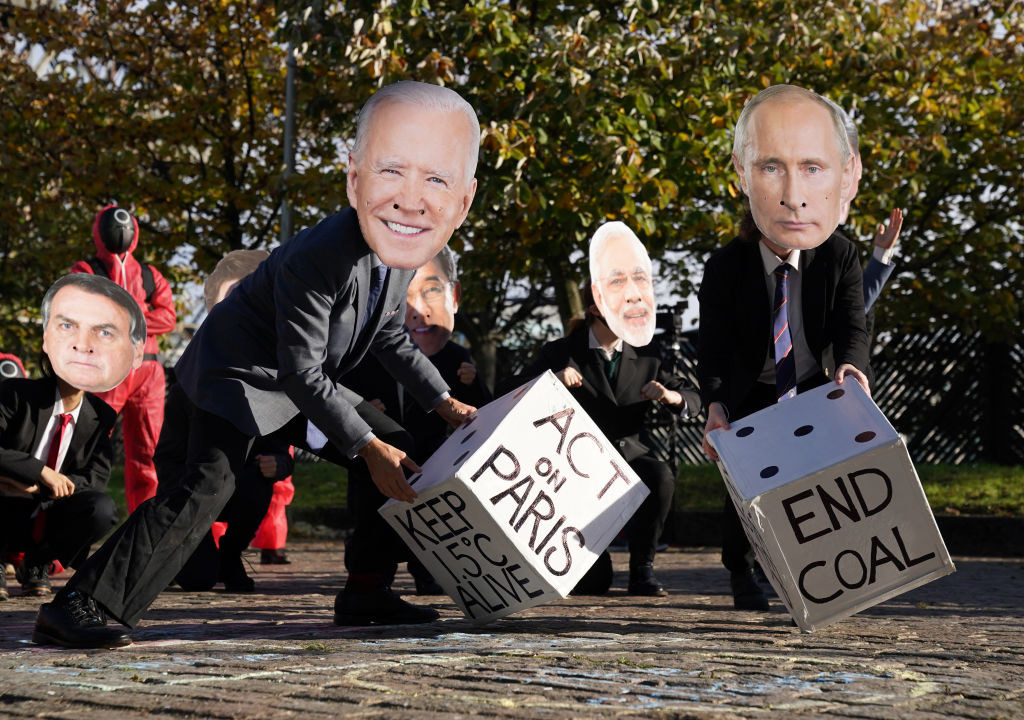 Protesters holding dice that say &quot;Act On Paris&quot; and &quot;End Coal&quot;