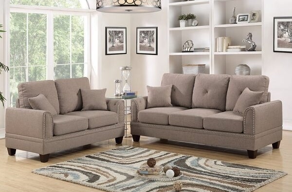 Two light brown couches around a blue, brown, and dark brown swirl rug