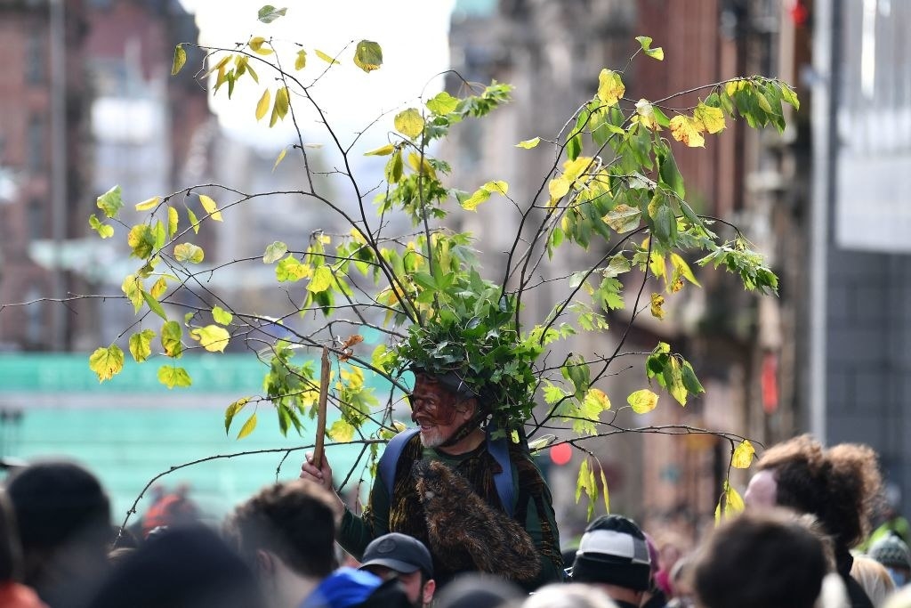 A protester with leaves attached to their back