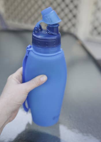 Reviewer holding the unrolled blue water bottle