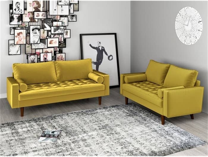 Two yellow velvet couches around gray and white rug