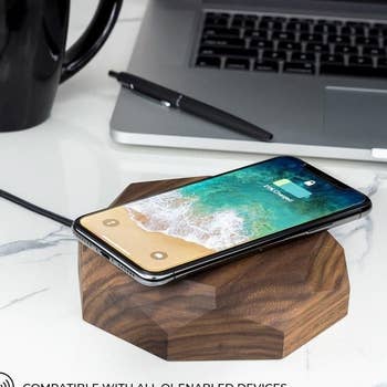 an iPhone sitting on a wooden wireless charger