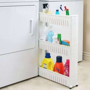 White sliding storage shelf with cleaning supplies on it