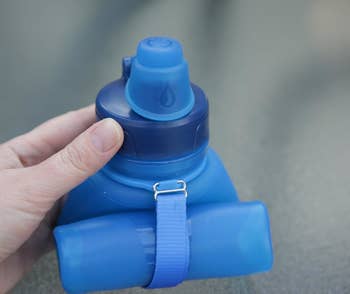 Reviewer holding the rolled up blue water bottle