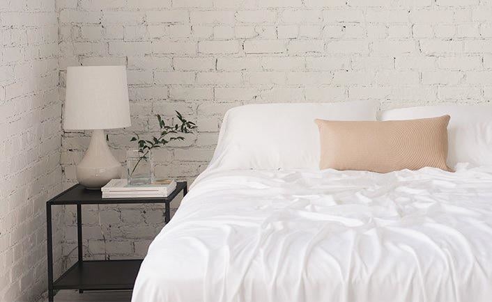 white sheets draped over a bed