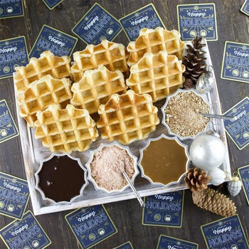 The included waffles and toppings laid out of a holiday tray