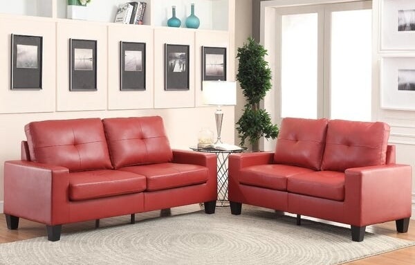 Two red couches around beige swirl rug