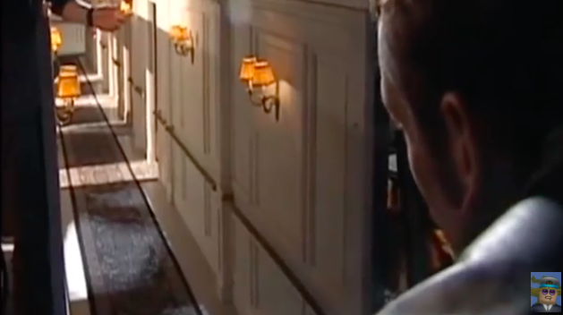 A man stares down in a miniature hallway