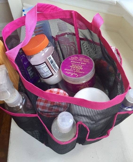 A pink and black shower caddy full of  reviewer&#x27;s items