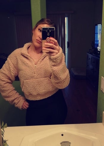 reviewer mirror selfie wearing brown cropped fuzzy hoodie