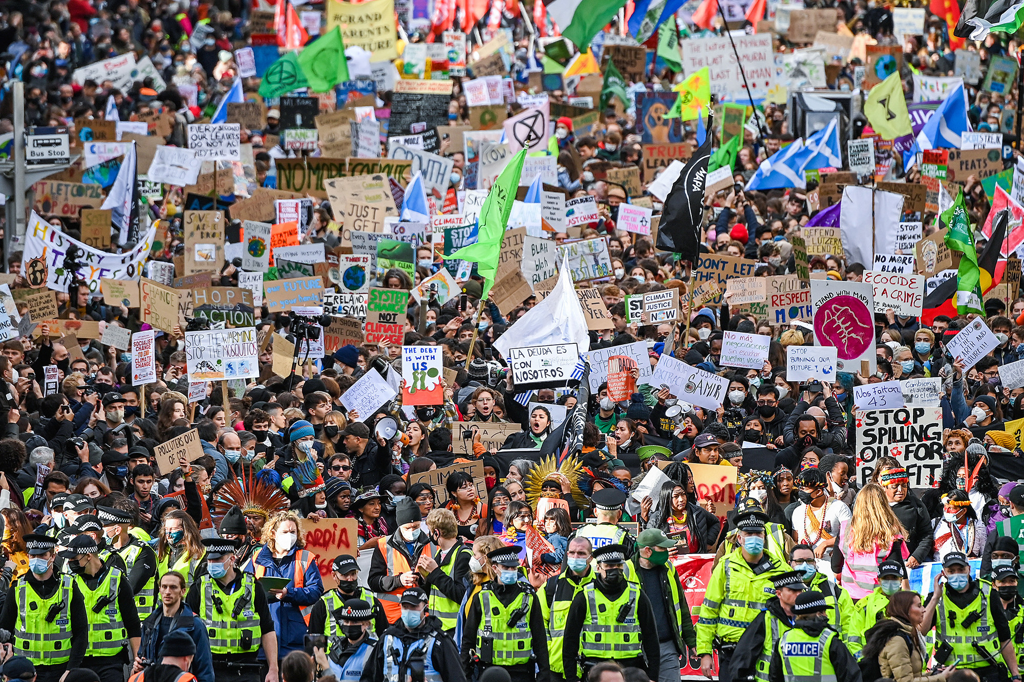 A massive crowd of people carry signs for climate justice