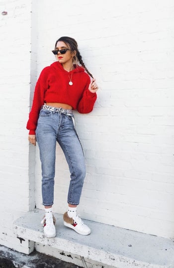 reviewer photo wearing the hoodie in red, posing against white wall