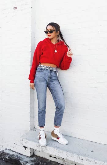 reviewer photo wearing the hoodie in red, posing against white wall